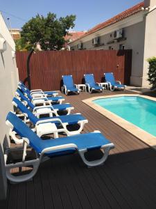 罗安达Casas de Luanda GH-Miramar的游泳池旁的一排蓝色和白色的躺椅