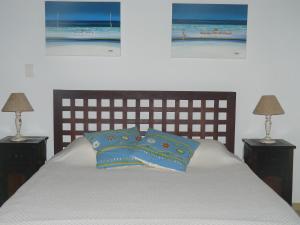 孔迪Pé na Areia的一间卧室配有一张带两盏灯和两张照片的床。