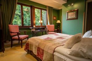 克拉科夫格罗德克酒店的一间拥有绿色墙壁的卧室和一张带两把椅子的床