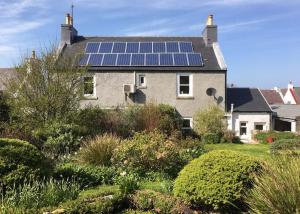 BowmoreAn Cuan Bed & Breakfast的屋顶上设有太阳能电池板的房子