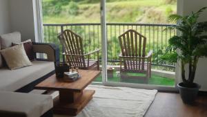 努沃勒埃利耶Lake Infinity Luxury Condos的客厅配有沙发和两把椅子,阳台