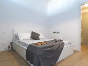 博洛尼亚Lazzaretto Apartments的白色的卧室,床上有毯子