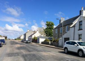 BowmoreAn Cuan Bed & Breakfast的街道上设有房屋和汽车的街道