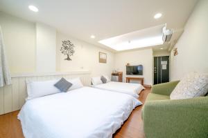台南台南树夏民宿的一间带两张床和一张沙发的卧室