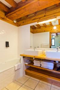 Saint-Jacques-dʼAmburLogis Hôtel Auberge de la Hulotte的浴室配有2个盥洗盆、浴缸和浴缸。