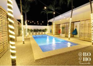 塔马林多BOHO Tamarindo的夜间有灯光的房子里的一个游泳池