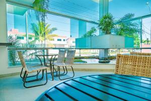 塞古罗港Vitoria Regia Praia Hotel的客房设有桌椅和大窗户。