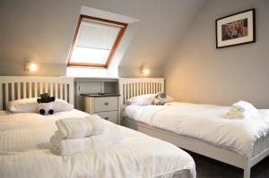 乌伊格5 Glenconon Bed and Breakfast的阁楼卧室配有两张带毛巾的床
