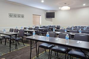 休斯顿Candlewood Suites Houston Westchase - Westheimer, an IHG Hotel的配有桌椅和瓶装水的房间