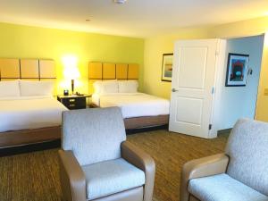 Belle VernonCandlewood Suites Belle Vernon, an IHG Hotel的酒店客房,配有两张床和椅子