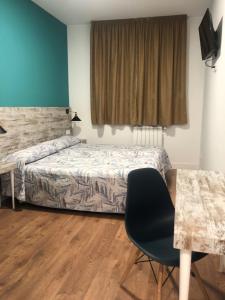 圣多明各德拉RoomConcept Hostel的一间卧室配有一张床、一张桌子和一把椅子