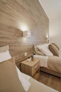 沃迪切俄里翁酒店的一间卧室设有两张床和木墙