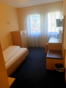 内卡河畔弗赖贝格罗斯勒酒店的一间小卧室,配有两张床和窗户