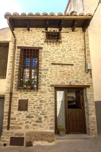 坎塔维耶哈Casa Rural El Portillo的石屋,带两个窗户和门