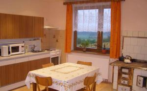 鲁达Holiday home in Ruda 2035的厨房配有桌子、微波炉和窗户。