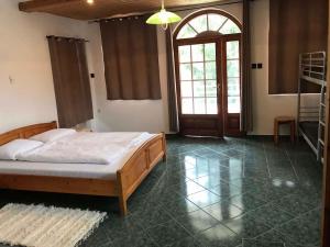 鲍洛通凯赖斯图尔Apartments in Balatonmariafürdo 37115的一间卧室设有一张床、一个大窗户和一扇门