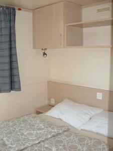 卡瓦利诺Mobilehomes in Cavallino-Treporti 33773的一间小卧室,配有床、橱柜和床