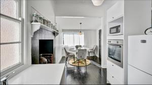 滕特菲尔德“唐纳利之家”度假屋的白色的厨房配有桌子和壁炉