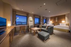 静冈静冈酒店的大型酒店客房设有床和电视。