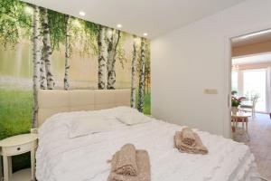 扎达尔HACIENDA MIA extra的卧室配有白色的床铺,墙上有树木