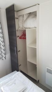圣让-德蒙MH 149 4 pers camping Bois Dormant confort et détente的卧室配有一张床和一个白色衣柜