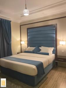 海米斯穆谢特القصر للاجنحة الفندقية الضيافة1的一间卧室配有一张大床和蓝色床头板