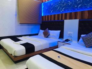门格洛尔Hotel Royal Inn Mangalore - Opp SDM Law College MG Road的蓝色和白色的客房内的两张床