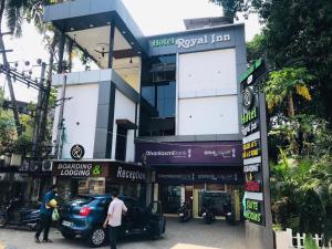 门格洛尔Hotel Royal Inn Mangalore - Opp SDM Law College MG Road的前面有停车位的建筑