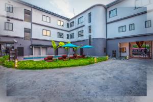 杜阿拉AKWA HIN Douala的公寓大楼设有带椅子和遮阳伞的庭院