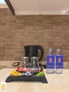 海米斯穆谢特القصر للاجنحة الفندقية الضيافة1的黑咖啡壶和柜台上的两瓶水