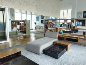 吉隆坡Grand Suite at Platinum KLCC的客厅配有沙发、椅子和书架