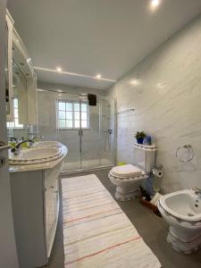 吉尔斯Cantinho Verde T3的一间带两个盥洗盆、淋浴和卫生间的浴室