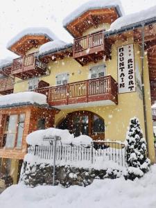 科姆梅扎杜拉高山度假村酒店的前面的雪覆盖的房子