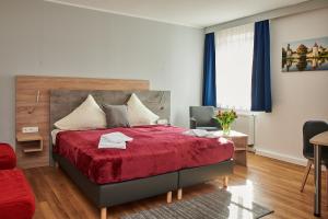 慕尼黑祖尔阿拉哈穆勒酒店的一间卧室配有红色的床和红色毯子