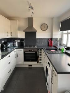 UpwellCosy Annexe With Peaceful Surroundings的厨房配有白色橱柜和炉灶烤箱。