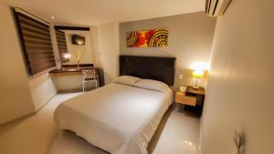 巴耶杜帕尔格兰德大道精品酒店的一间卧室配有一张床、一张桌子和一个窗户。