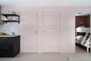 GärsnäsStockeboda Gård的卧室设有两扇白色门,配有双层床