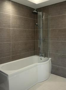 StonefortErinona House的浴室配有白色浴缸和淋浴。