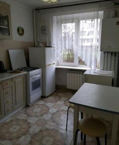 特鲁斯卡韦茨Затишна 1 кімнатна квартира Трускавець的厨房配有冰箱、桌子和窗户。