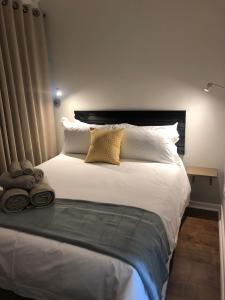 约翰内斯堡The Haystack on Cowley的卧室配有一张带白色床单和枕头的大床。