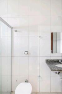 大坎普Nosso Hotel的白色瓷砖浴室设有卫生间和水槽