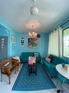 仙本那Suhana HomeStay Semporna - Cozy Home的客厅配有蓝色的沙发和桌子