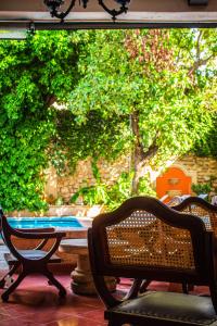 梅里达Casa del Balam Merida的庭院配有两把椅子和桌子,树木繁茂