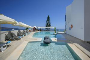 斯塔罗斯Hermes Sea View的一个带躺椅和遮阳伞的游泳池