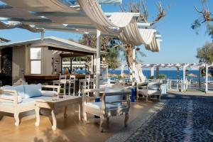 卡马利Seaside by Manos的一个带桌椅和遮阳伞的庭院