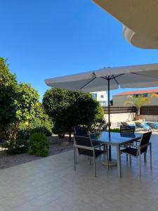 利马索尔EPISKOPI VILLA, Luxury 4 Bedroom with Pool - Limassol的庭院内桌椅和遮阳伞