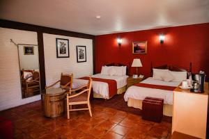 伊达尔戈德尔帕拉尔HOTEL BOUTIQUE EL VIEJO MUNDO的酒店客房,设有两张带红色墙壁的床