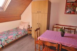 鲍洛通维拉戈什Apartment in Balatonvilagos 35847的一间卧室配有桌子、床和橱柜