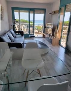 马尔格莱特德玛Apartamento Malgrat de mar的客厅配有玻璃桌和椅子