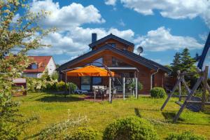 岑平Holiday home in Zempin (Seebad) 3240的院子里带橘子伞的房子